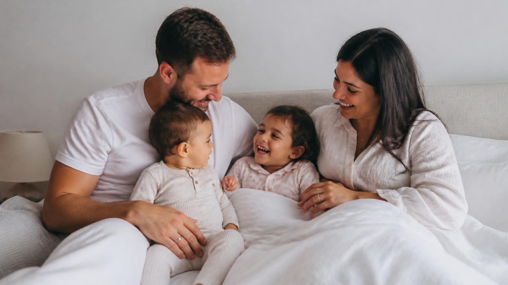 Illustrative family cuddling in bed