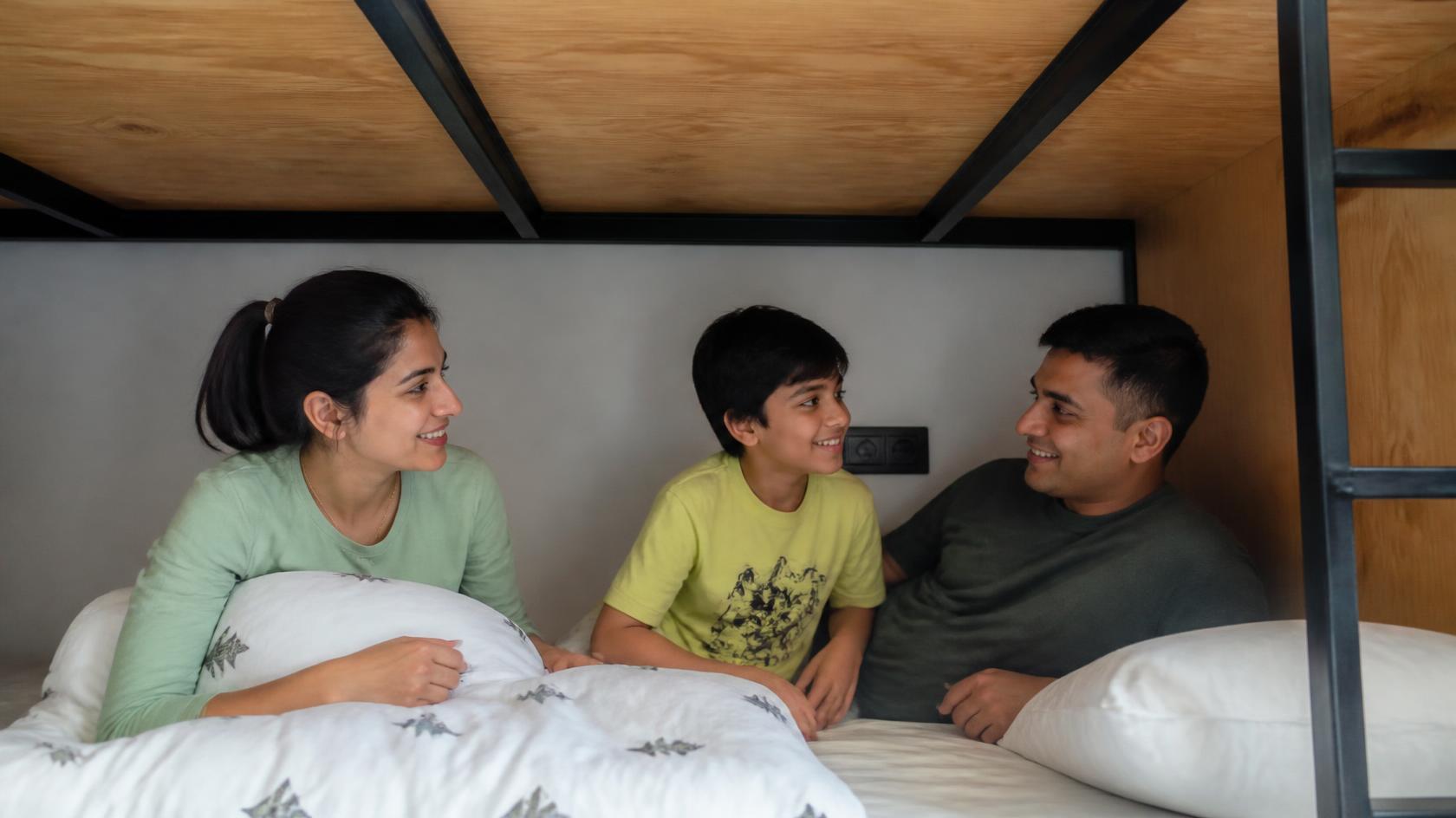 Illustrative family sitting together on a lower bunk bed
