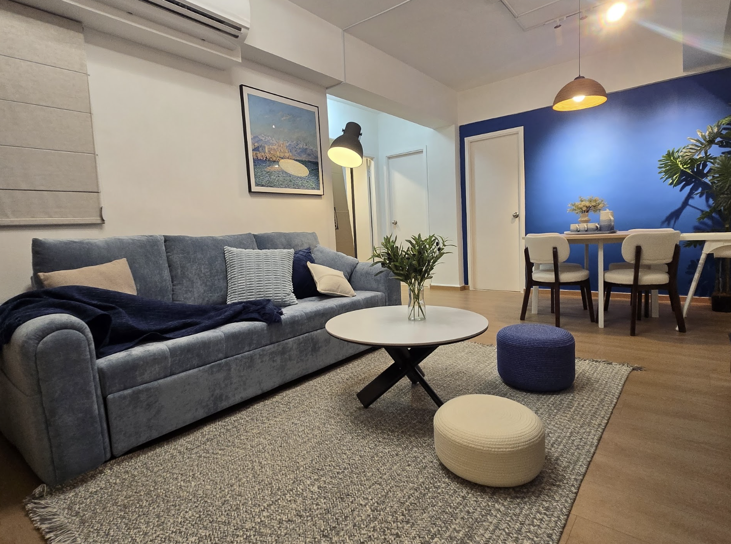 Living and dining room with blue feature wall and grey sofa