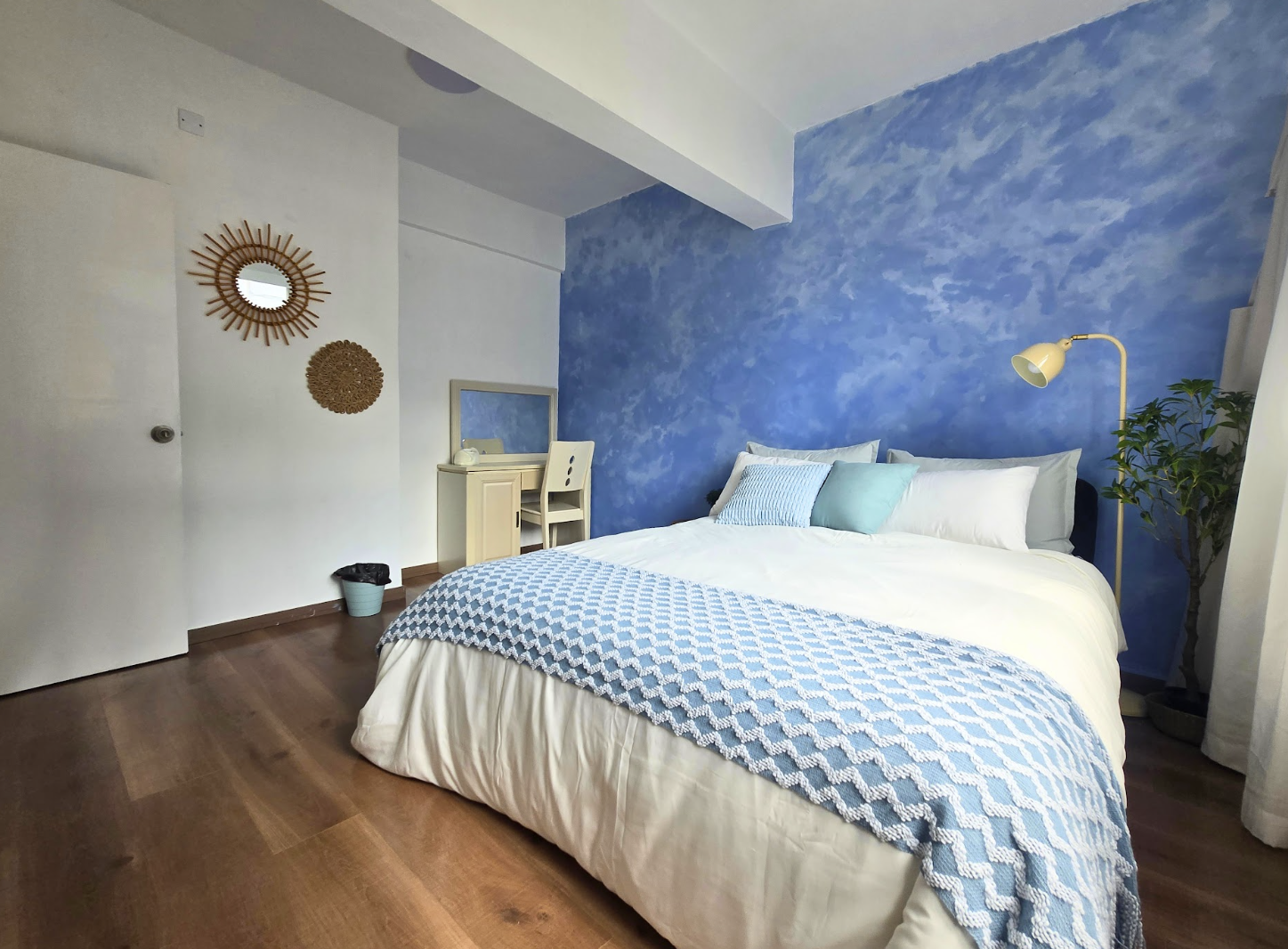 Bedroom with blue textured wall and white bedding